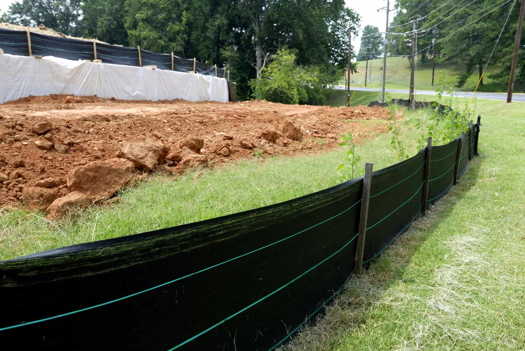 Close-up view of silt fencing at construction site with bare dirt from grading in background